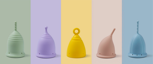 Pastel coloured period cups on a coloured background.