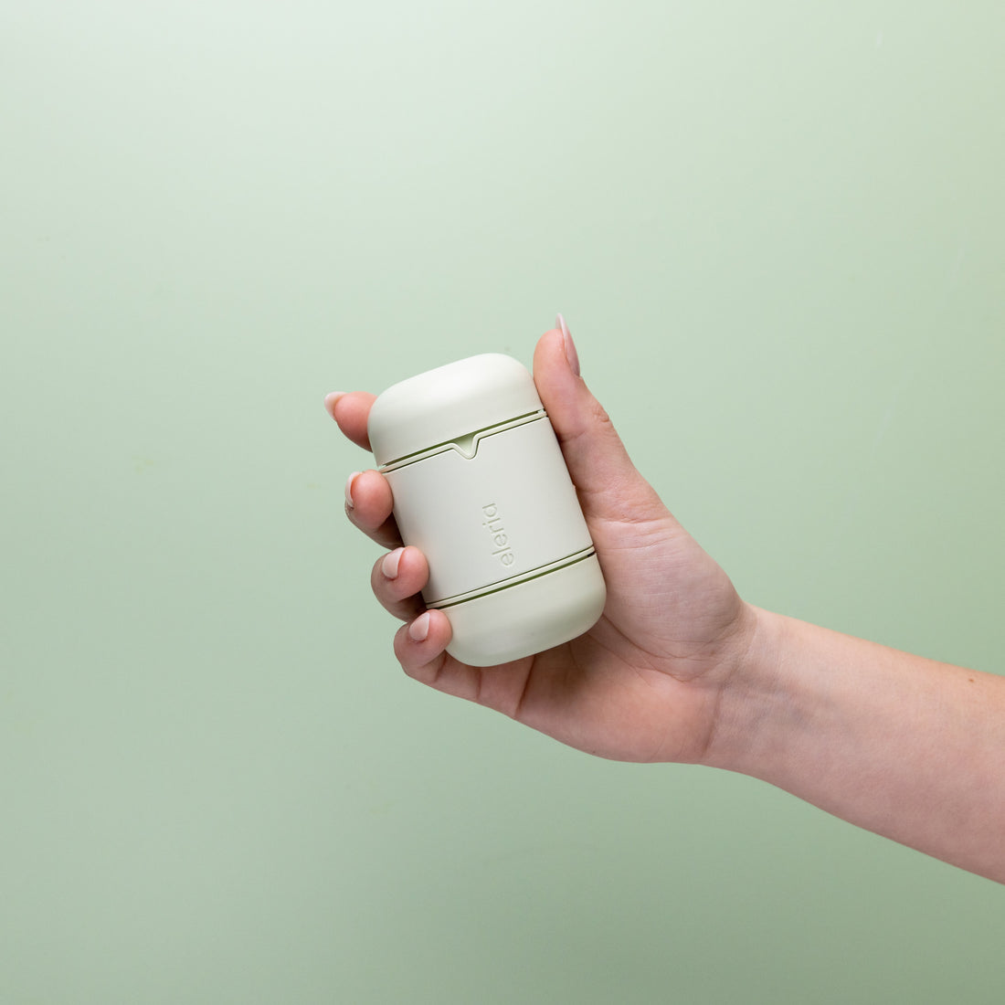 Hand holding green case with notch and Eleria logo on green background.