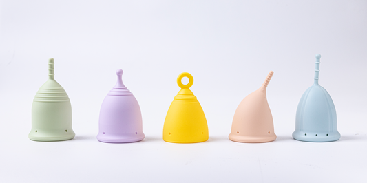 Five different coloured and shaped menstrual cups.