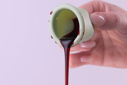 Green menstrual cup pouring fake blood. 