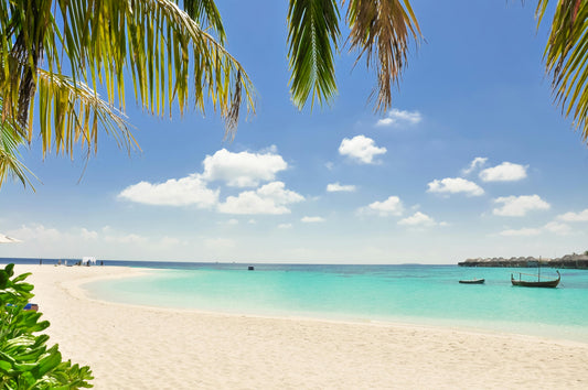 Sandy beach holiday destination, blue sky, and clear blue ocean. 